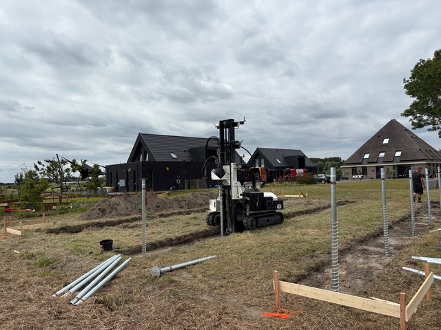 Rupsmachine plaatst schroefpalen voor woningbouw